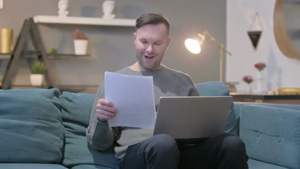 Casual Manwith Laptop Having Success on Documents Sofa