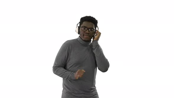 Smiling African American Man in Headphones and Moving To the Music Rhythm on White Background