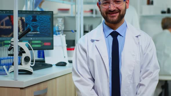 Portrait of Scientist Man Smiling at Camera Sitting in Modern Laboratory