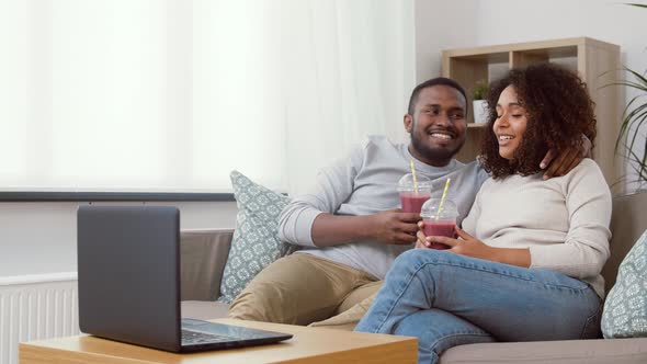 Couple with Laptop and Straw Drinks at Home