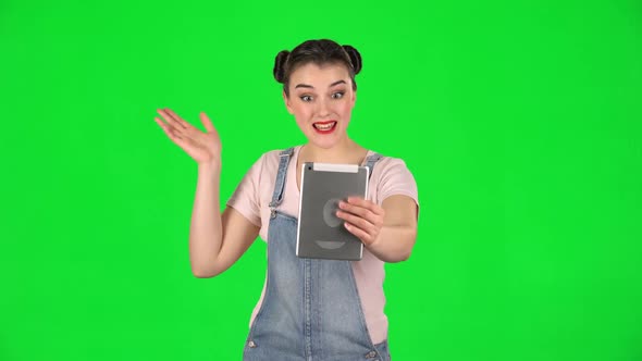 Smiling Girl Talking for Video Chat Using Tablet Computer on Green Screen