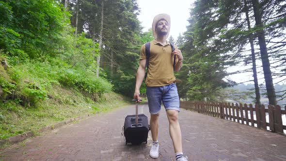 Male tourist carrying his suitcase.