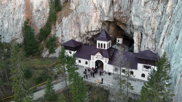 Aerial drone view of The Ialomitei Cave in Romania. Entrance into the cave with tourists in Bucegi M