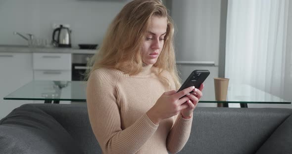 Dreamy Positive Beautiful Young Girl in Casual Clothes Sitting Couch at Home When Thinking About