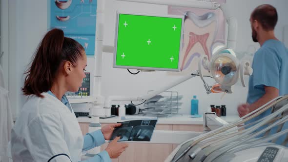 Dentist Looking at Monitor with Horizontal Green Screen