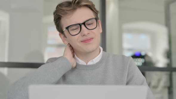 Close Up of Young Man with Neck Pain Working on Laptop