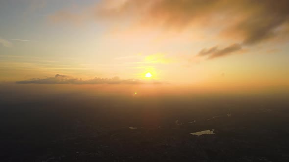 Aerial View From High Altitude of Distant City Covered with Puffy Cumulus Clouds Forming Before