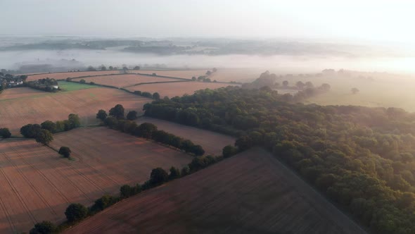 Aerial footage of fields at Lexden Heath near Colchester in early morning mist at sunrise.