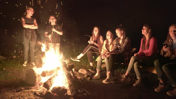 Teens Looking at Bright Campfire.