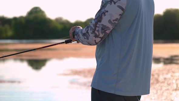 The Fisherman Sportsman Catches a Predatory Fish on a Spinning on the Lake