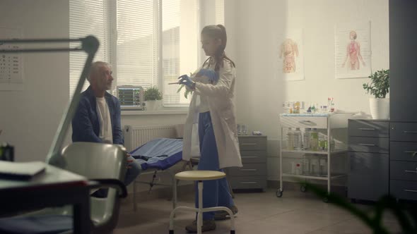 Woman Therapist Examining Senior Patient Throat