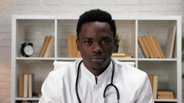 African American Man Doctor in Medical Coat Looking at the Camera in Hospital