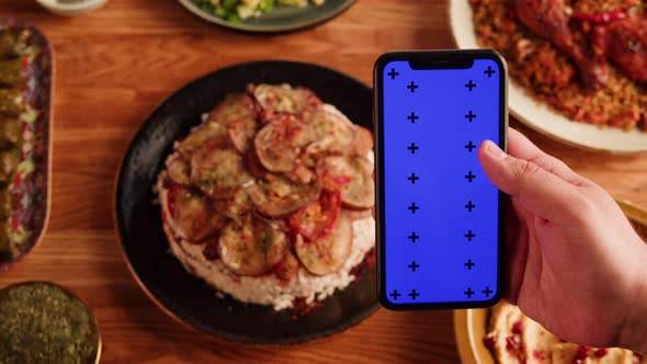 Maqluba Hummus Dolma Kabsa Tabbouleh Closeup Smartphone with Blue Chroma Key Screen Middle Eastern