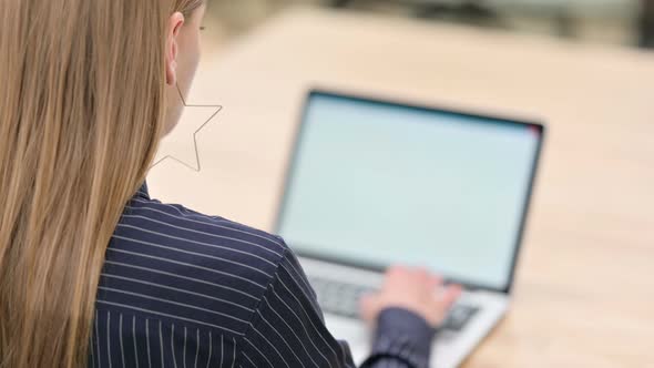 Rear View of Businesswoman Working on Laptop 