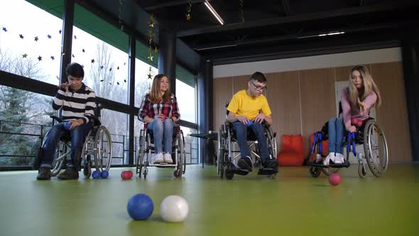 People in Wheelchairs Enjoying Boccia Game Indoors
