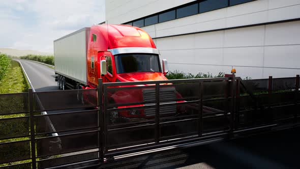 Red truck with heavy cargo. The gate opens and a giant lorry entering parking.