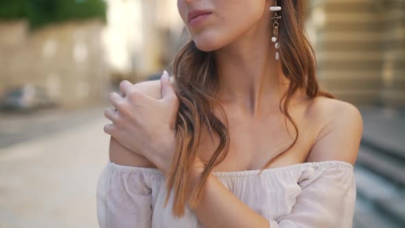 Girl Gently Touches Her Shoulder Outdoors