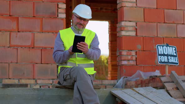 Builder Engineer Architect Operate with Digital Tablet to Control Working at Construction House Site