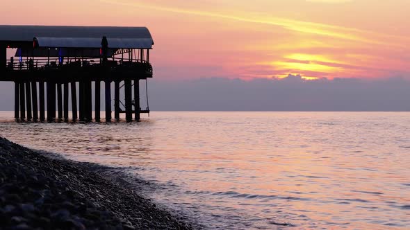 Panorama of the Sunset Over the Sea Next To the Silhouette of the Pier.