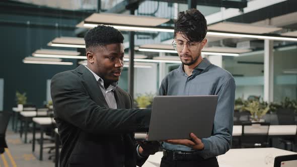 Two Male Business Partners Men Arabian Man Holding Laptop Showing Presentation African Businessman