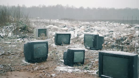 Broken TVs at the Garbage Dump with the Falling Snow