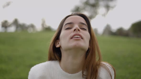 Closeup of Face of Young Woman Breathing Heavily and Laughing Outdoors