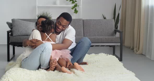 Young Parents Beautiful Woman Mom and Attractive Man Dad in White Casual Clothes Sitting at Home in