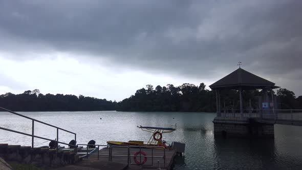 Cloudy  dark rainy and gloomy weather of a lake reservoir with small hut and rescue boat.