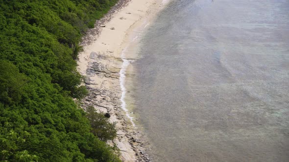 Hidden beach on a tropical island, with waves rolling onto its shore, Fiji 4K