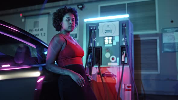 Portrait of African-American Woman Charging Car at Night