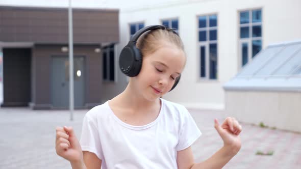 Young Teenager with Ponytail and Black Earphones Dances