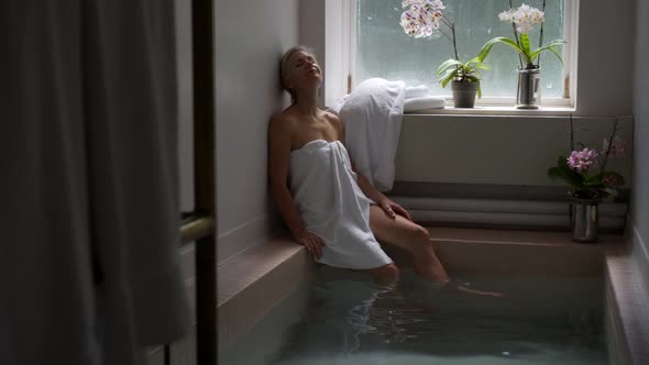 Beautiful mature woman in historic Roman Bath in Berkeley Springs State Park with lotus flowers and