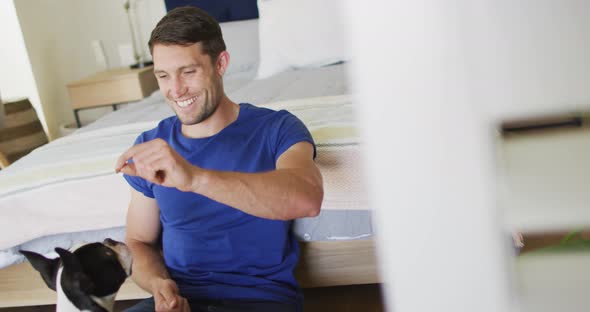 Caucasian man is playing with his dog at home