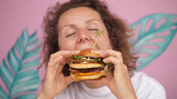 Close Up of Hungry Caucasian Woman Taking Bite of Doubledecker Vegan Burger