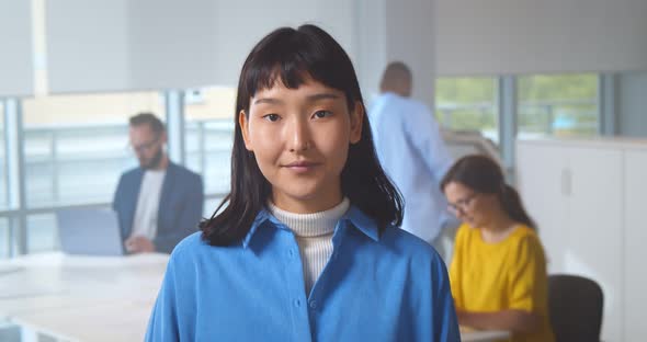 Portrait of Smiling Asian Woman in Creative Office