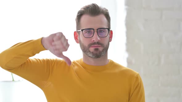 Portrait of Man Showing Thumbs Down Gesture