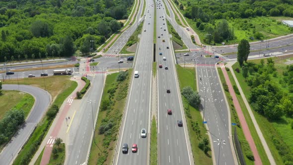 Top view of freay road. Clip. Highway with traffic in forest. Suburban highway with cars and trucks.