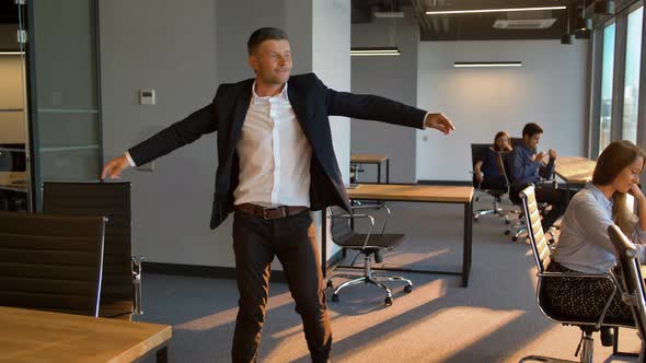 Group of Business People Looking at Dancing Male Colleague