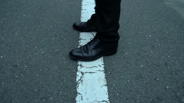 Worried man in black waits on the street