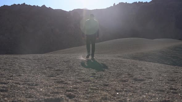 Man Walking Through Moon Like Location Of Stones And Gravel