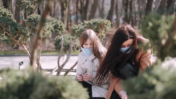 European Mother and Her Daughter Are Walking with a Dog During Quarantine in the Spring Park