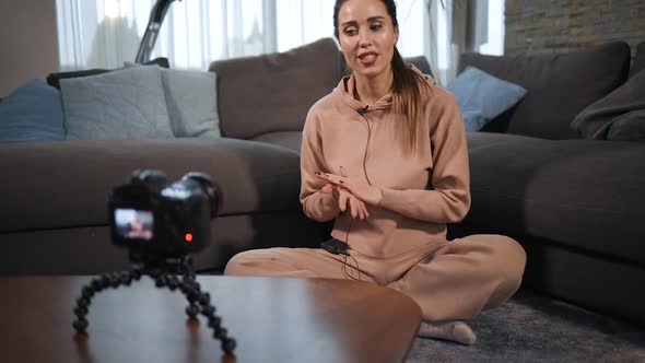 Young Female Yoga Blogger Records Tutorial Using Lav Microphone