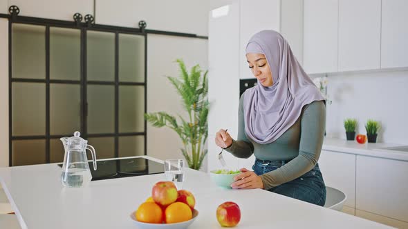 Muslim Woman Eating Salad in the Kitchen