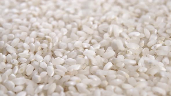 Dry white rice. Asian traditional ingredient. Macro. Slow rotation