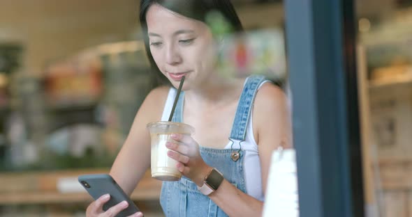 Woman use of mobile phone inside coffee shop