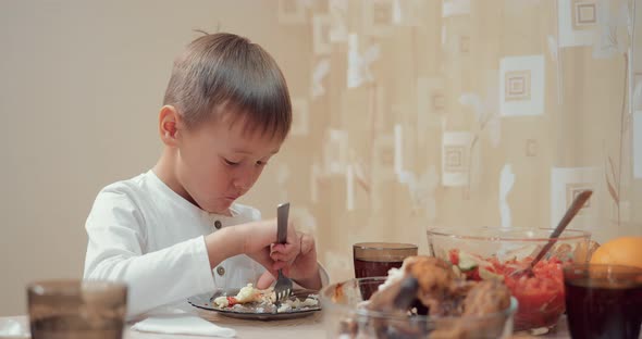 Small Boy Eats a Mashed Potato with Chicken and Drinks a Drink