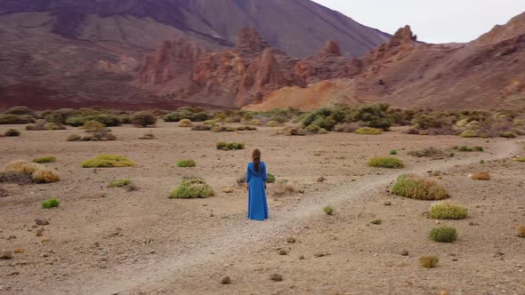 Woman in a Blue Dress in the Middle of a Landscape of Hardened Lava in the Teide National Park