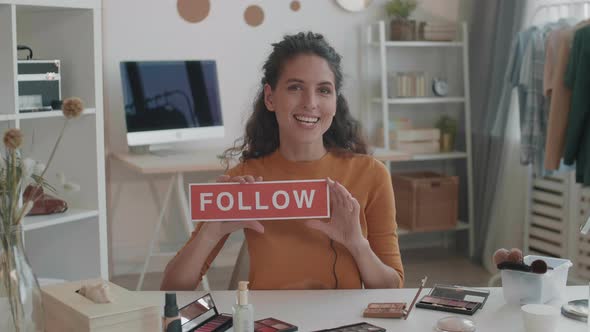 Female Vlogger Holding Follow Sign