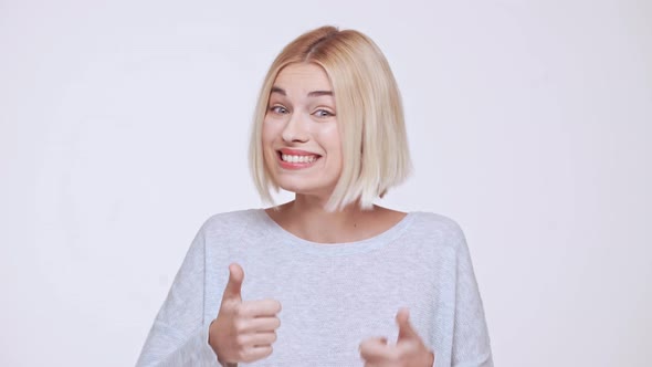Young Beautiful Blonde Girl Surprised Excited Showing Thumb Up Over White Background