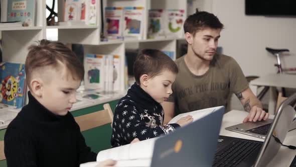 Two Little Boys are Reading Books Related to Computers and Programming